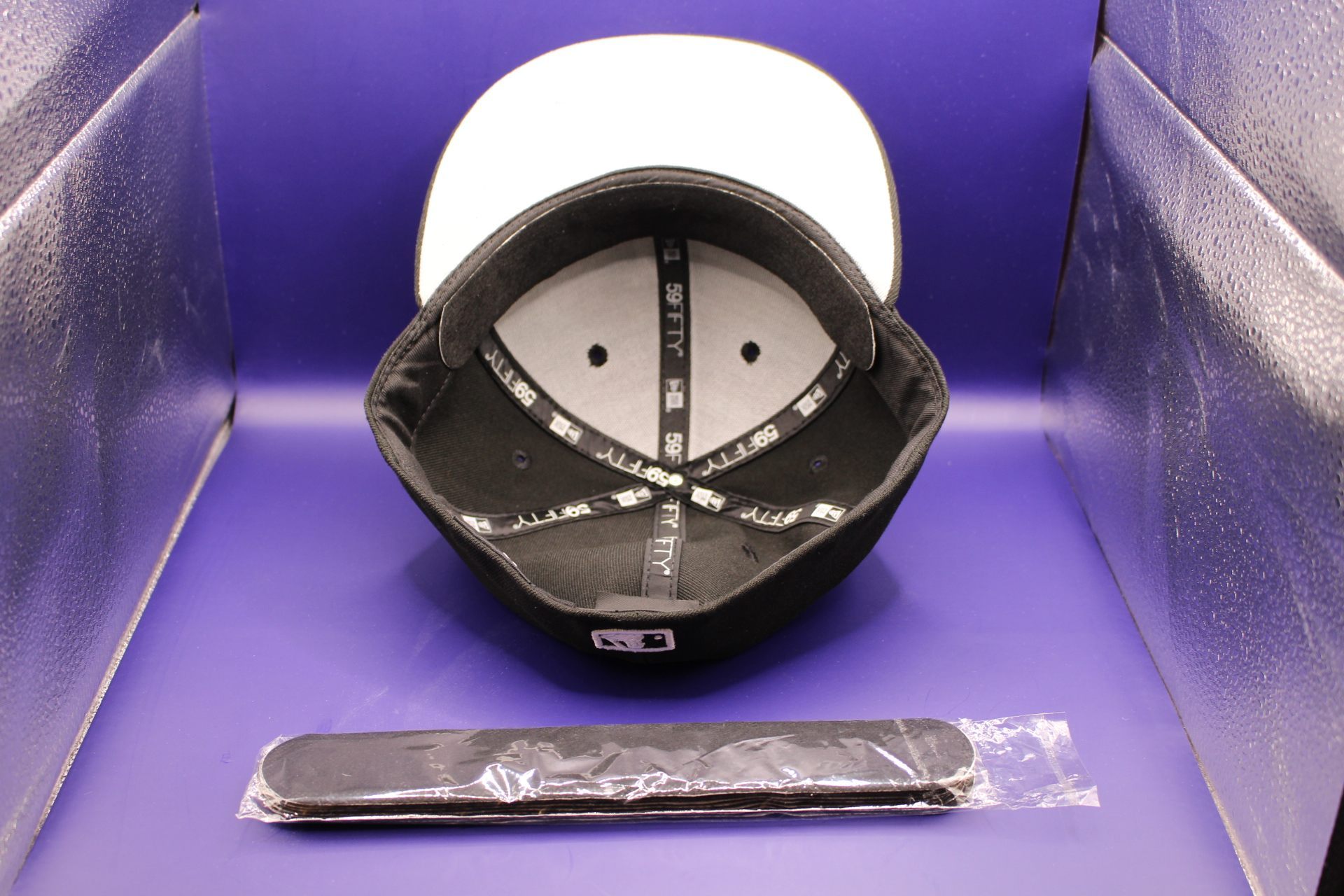 black hat liner in new black hat, with a hat liner not stuck to hat displayed 