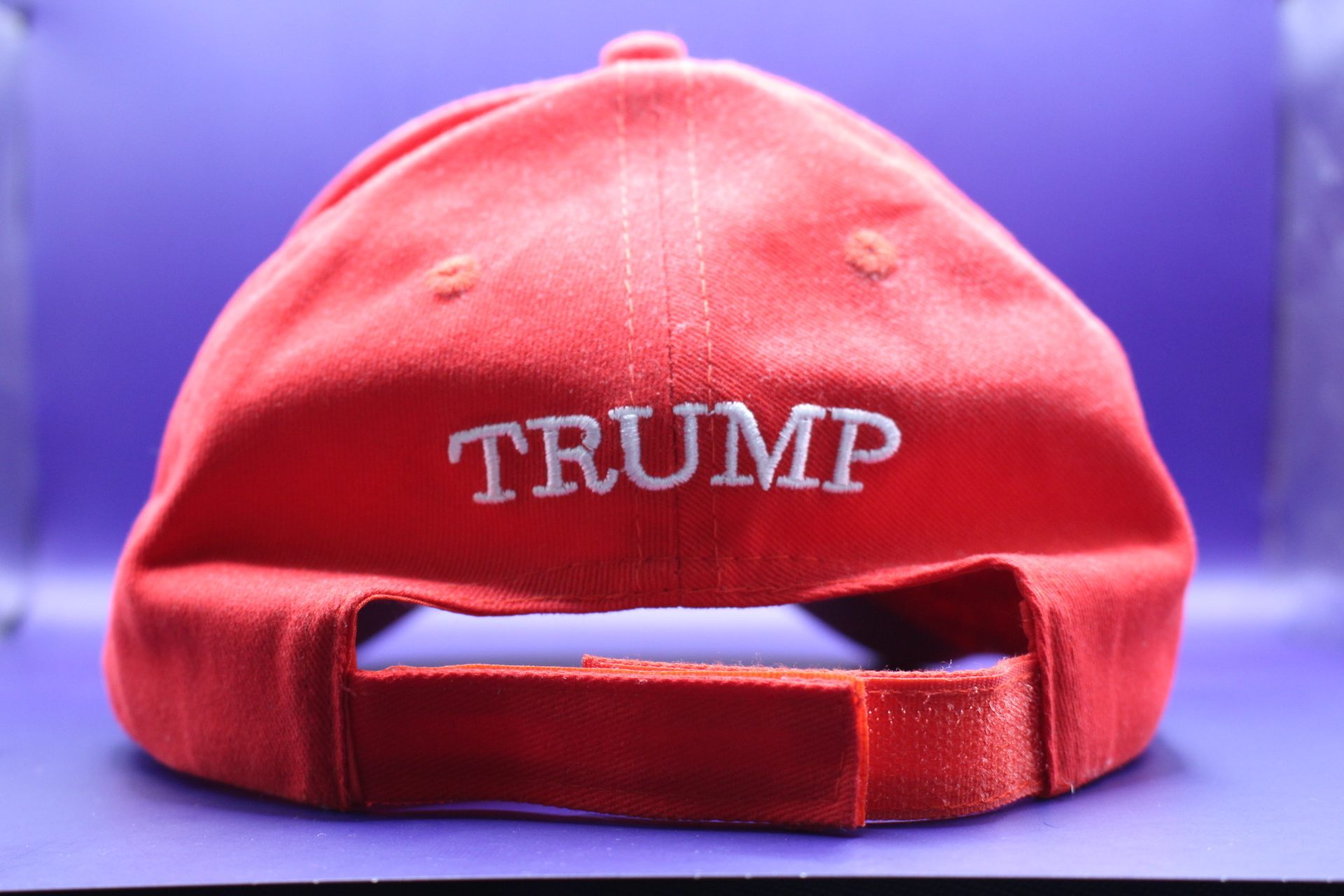 velcro adjustable strap of MAGA cap, with the word "TRUMP" over it, from Temu